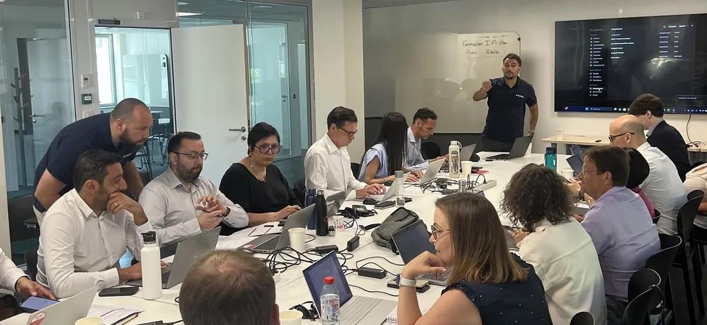 Hackathon IA au siège de G7 : un formateur Wavia présente Claude à l'écran, les participants travaillent sur leurs ordinateurs autour d'une grande table