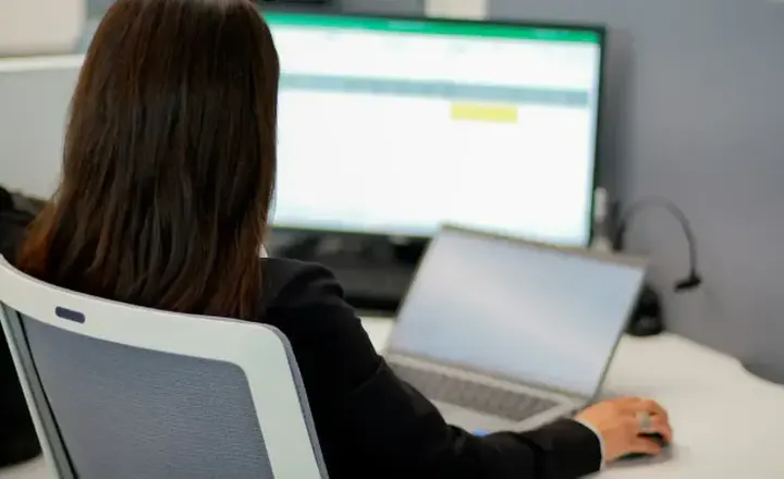 Une commerciale prépare ses rendez-vous avec l'IA devant son ordinateur