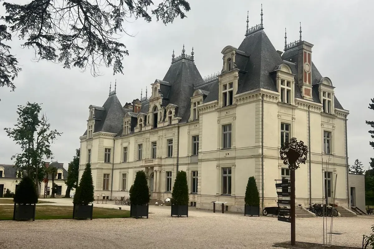 Façade du Château de Maubreuil à Carquefou, toits d'ardoise et cour gravillonnée bordée d'ifs