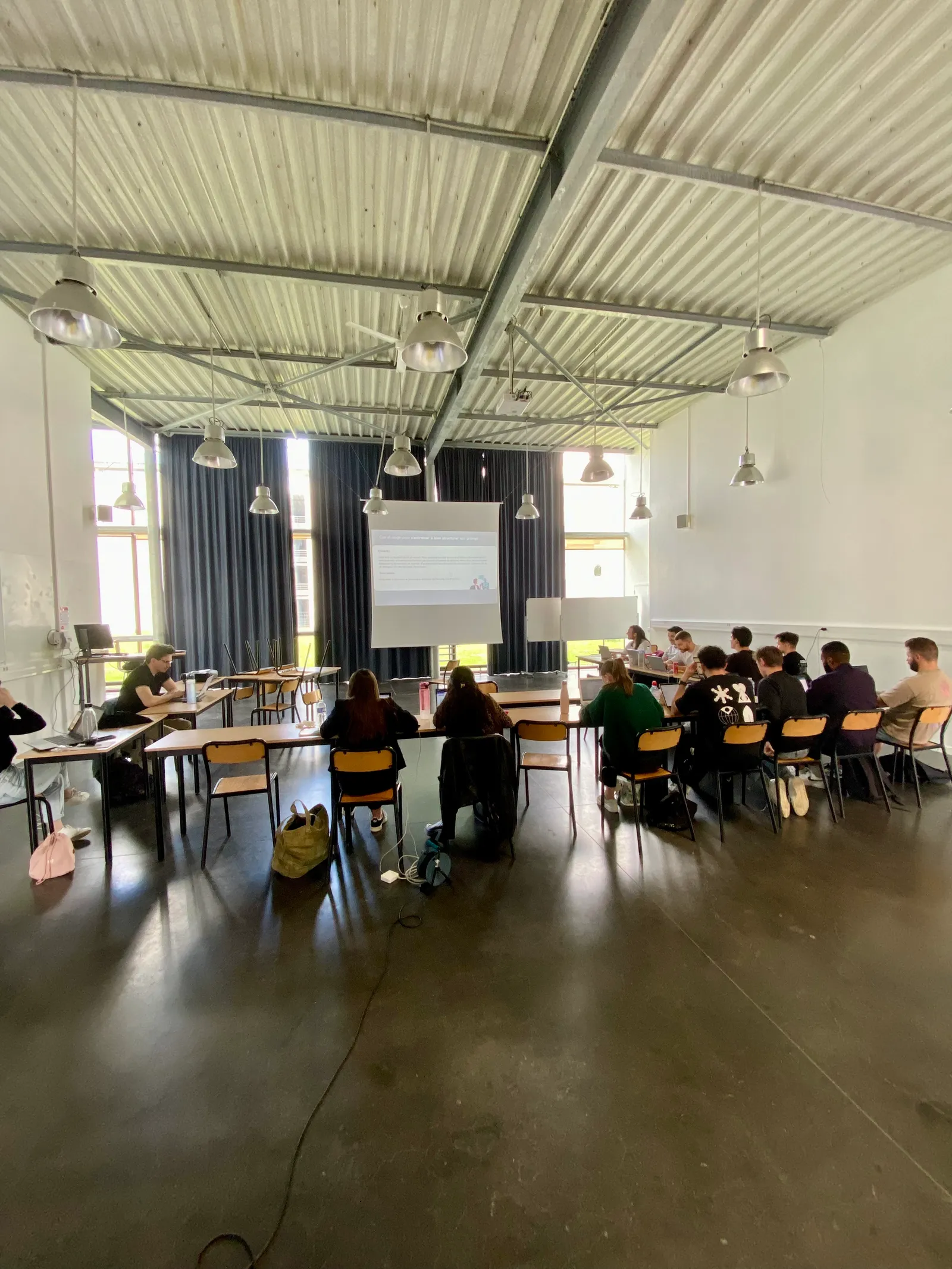 Session de formation IA Wavia dans une grande salle d’école, participants face à l’écran
